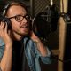 man with headphones singing at recording studio e1688574288626.jpg